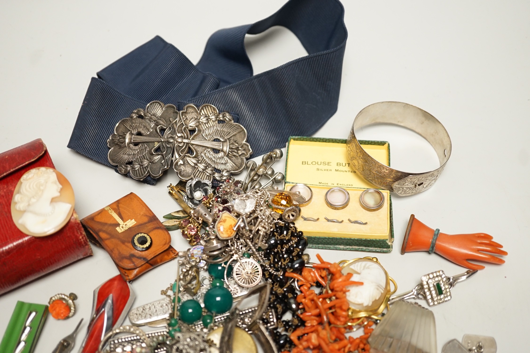 Assorted costume jewellery and other items including a silver belt buckle and enamelled egg pendant.
